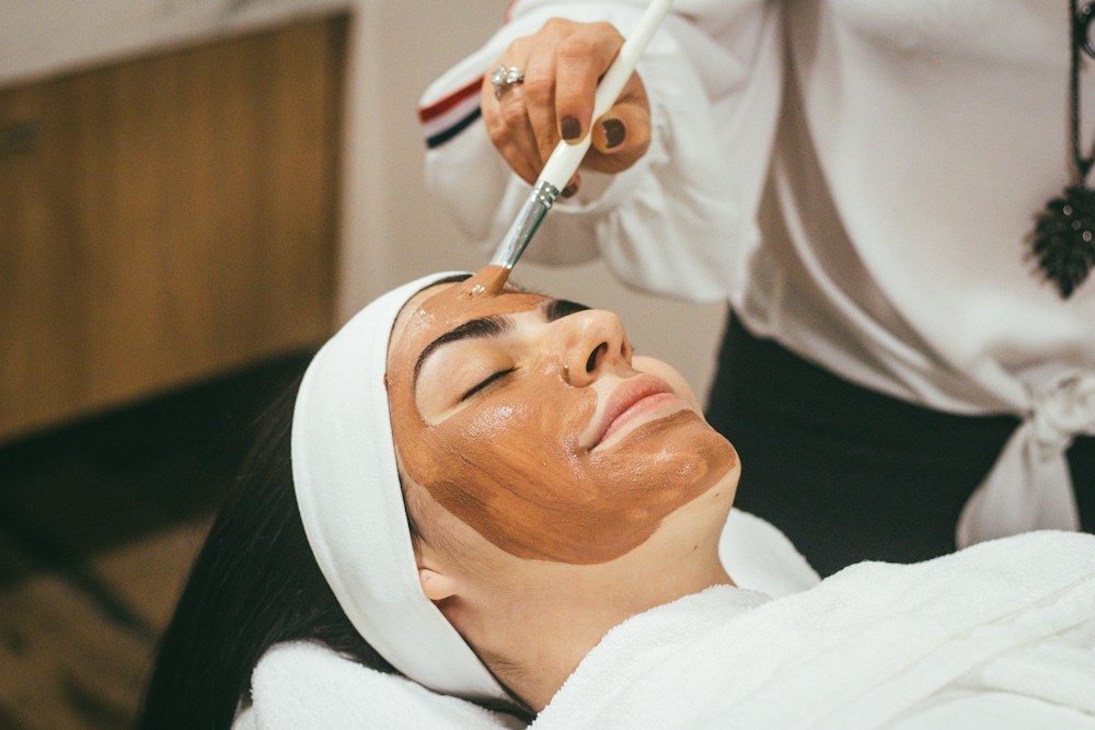 Therapist applying a facial mask with a brush