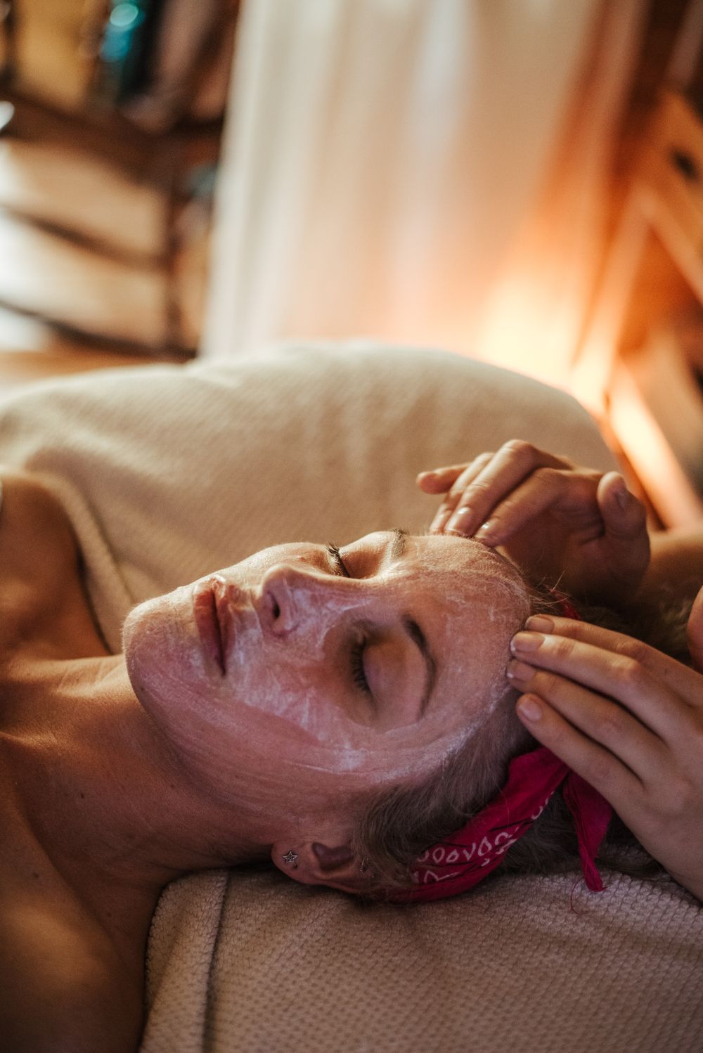 A client receiving a facial mask and massage treatment